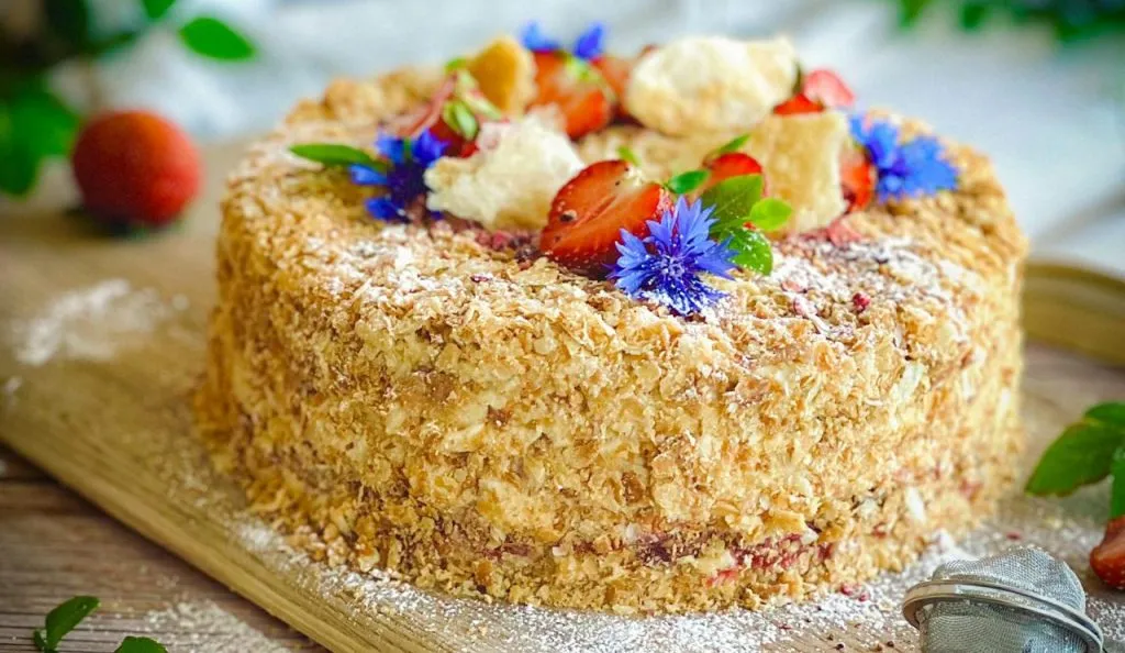 A tempting Napoleon cake adorned with strawberries and cornflowers, perfect for dessert lovers.