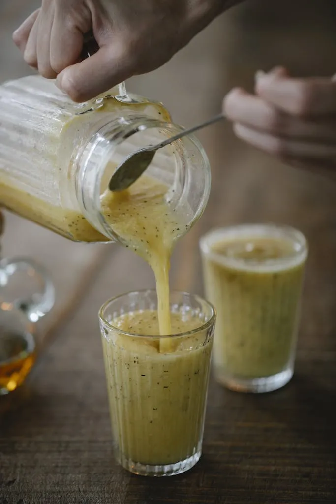 Refreshing kiwi smoothie being poured into a glass, capturing the essence of a vibrant, healthy beverage.