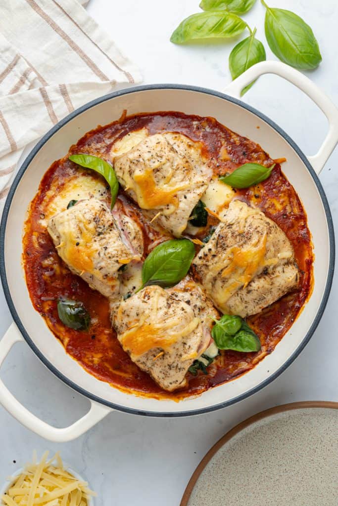 Skillet of chicken roll ups baked in marinara with melted parmesan