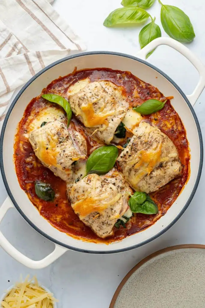 Skillet of chicken roll ups baked in marinara with melted parmesan