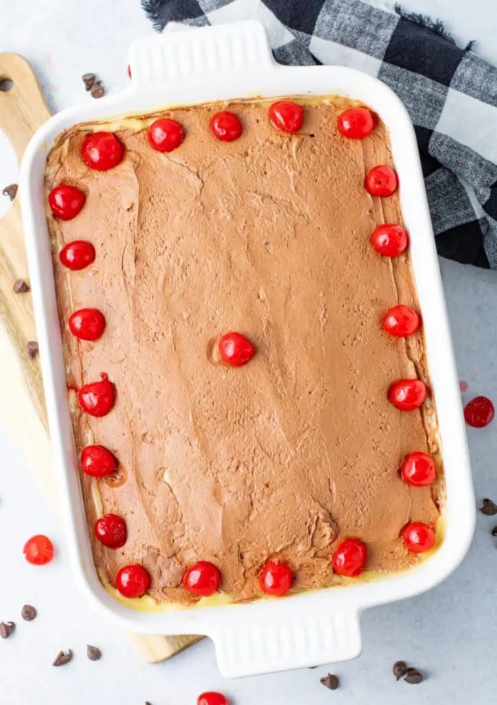Overhead of 9×13 Boston Cream Poke Cake with pudding pokes and chocolate topping
