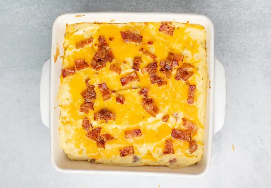 Baked mashed potatoes with melted cheddar and crispy bacon on top