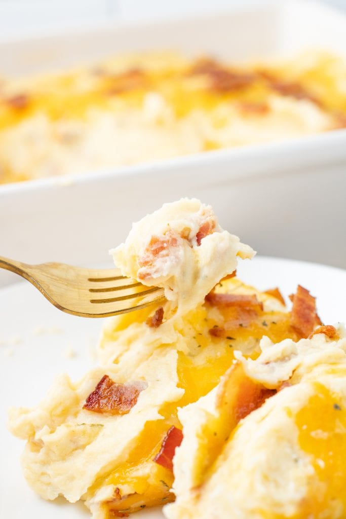 Close-up of creamy mashed potatoes garnished with parsley and bacon