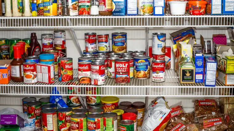 canns and jars of food that are pantry staples to make meals out of on a white wire rack.