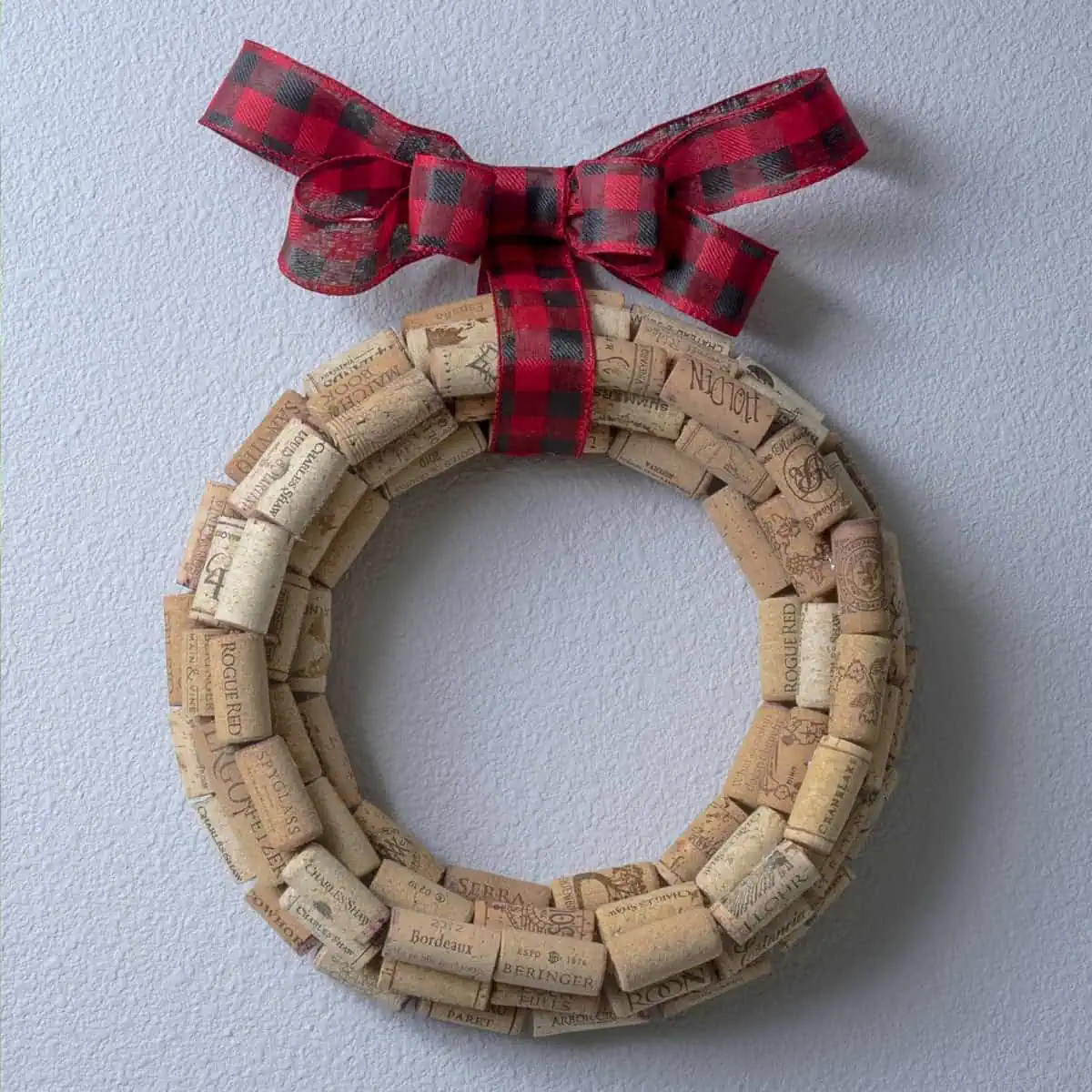 a round wine cork wreath with a christmas plaid ribbon
