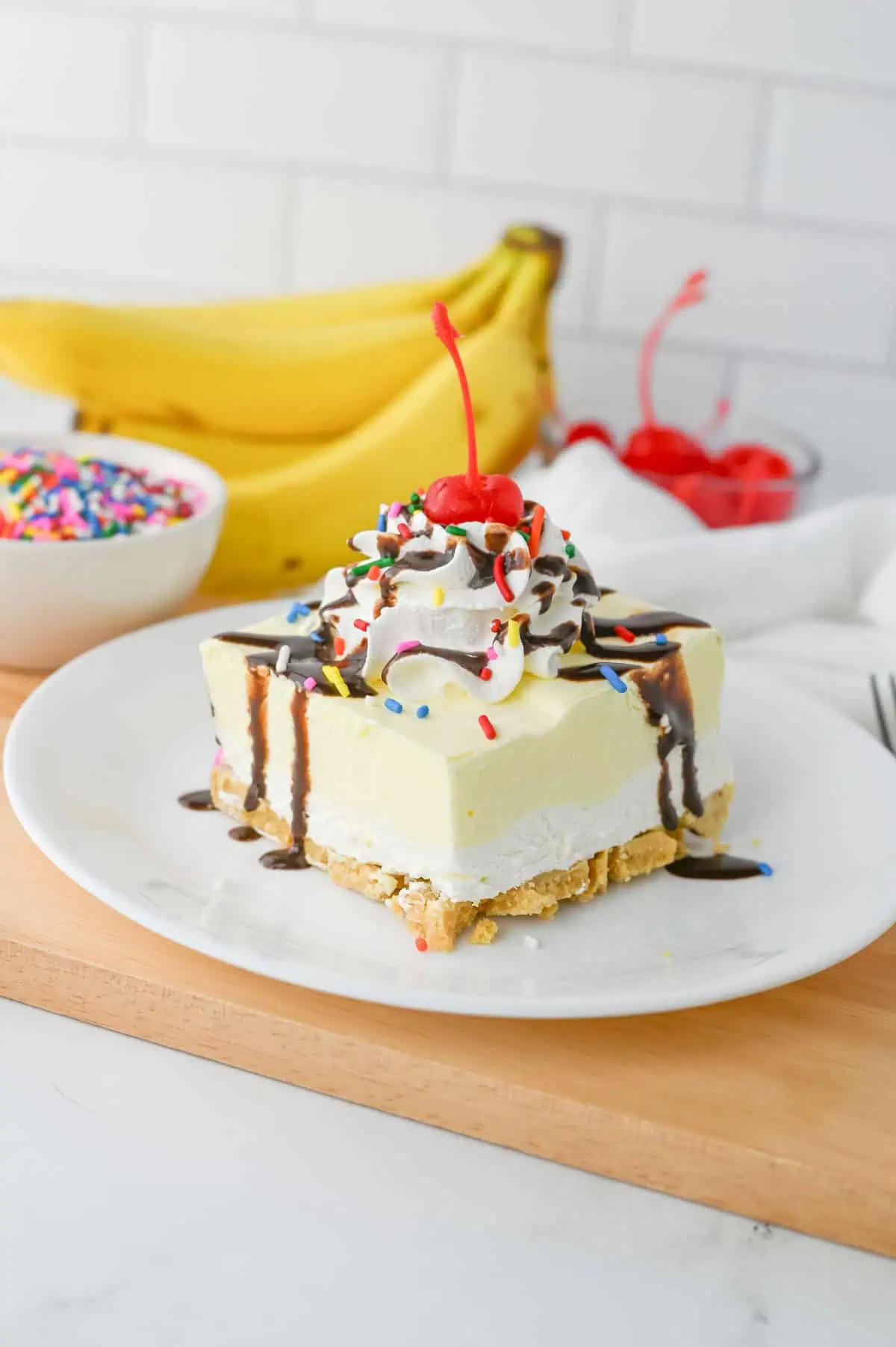 Close-up slice of Banana Split Lush showing the Golden Oreo crust, fluffy cream cheese filling, and thick creamy banana pudding layer.