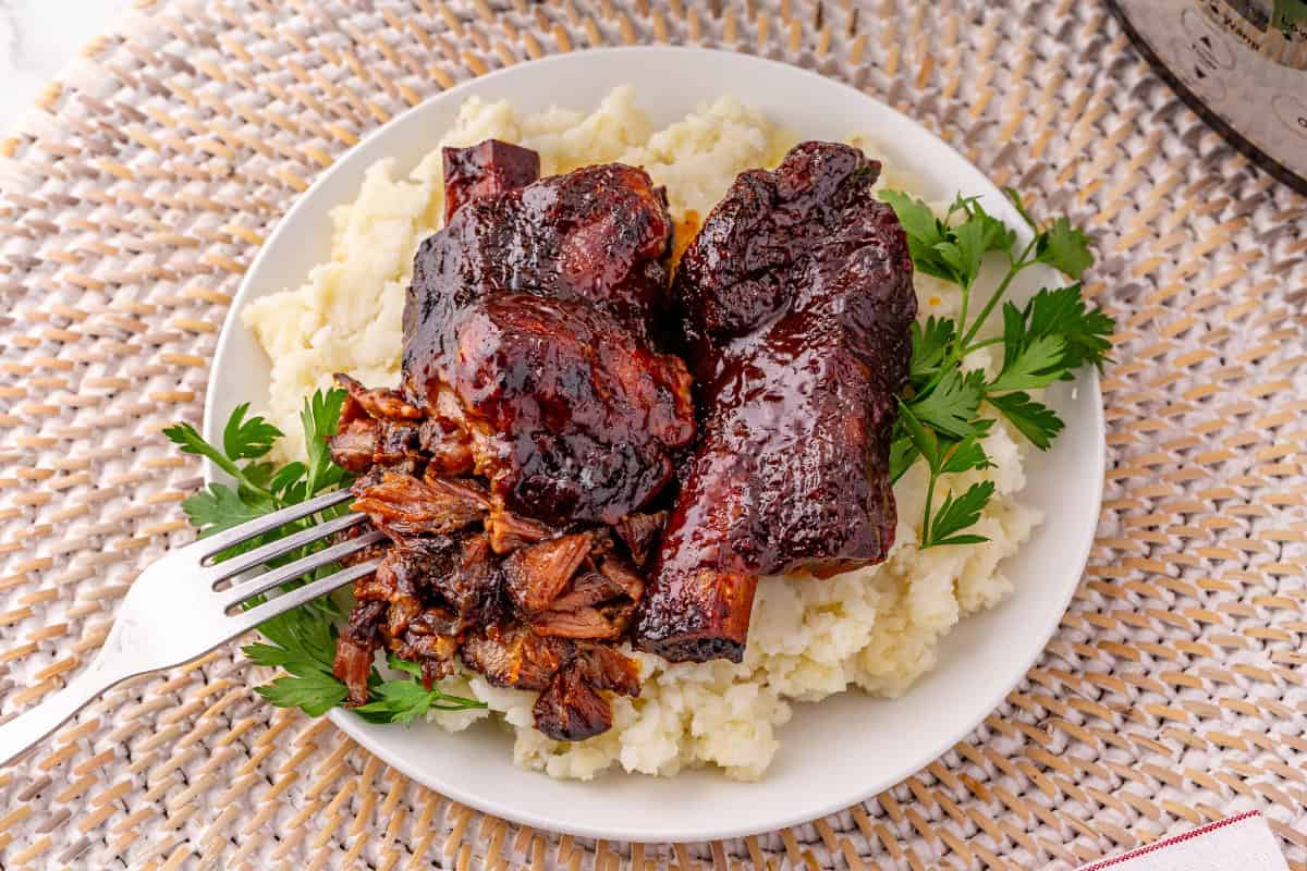 Close-up of fall-off-the-bone beef ribs pulling apart with a fork
