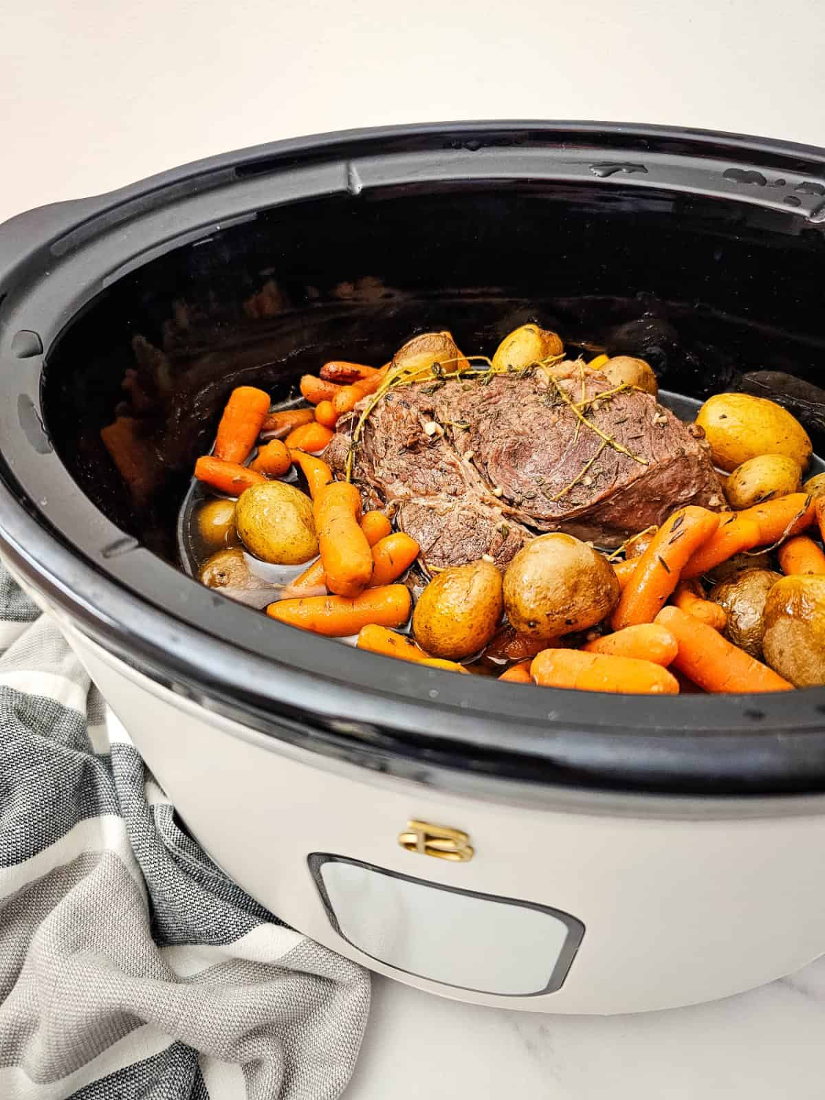 Finished slow cooker chuck roast served with tender baby potatoes and carrots