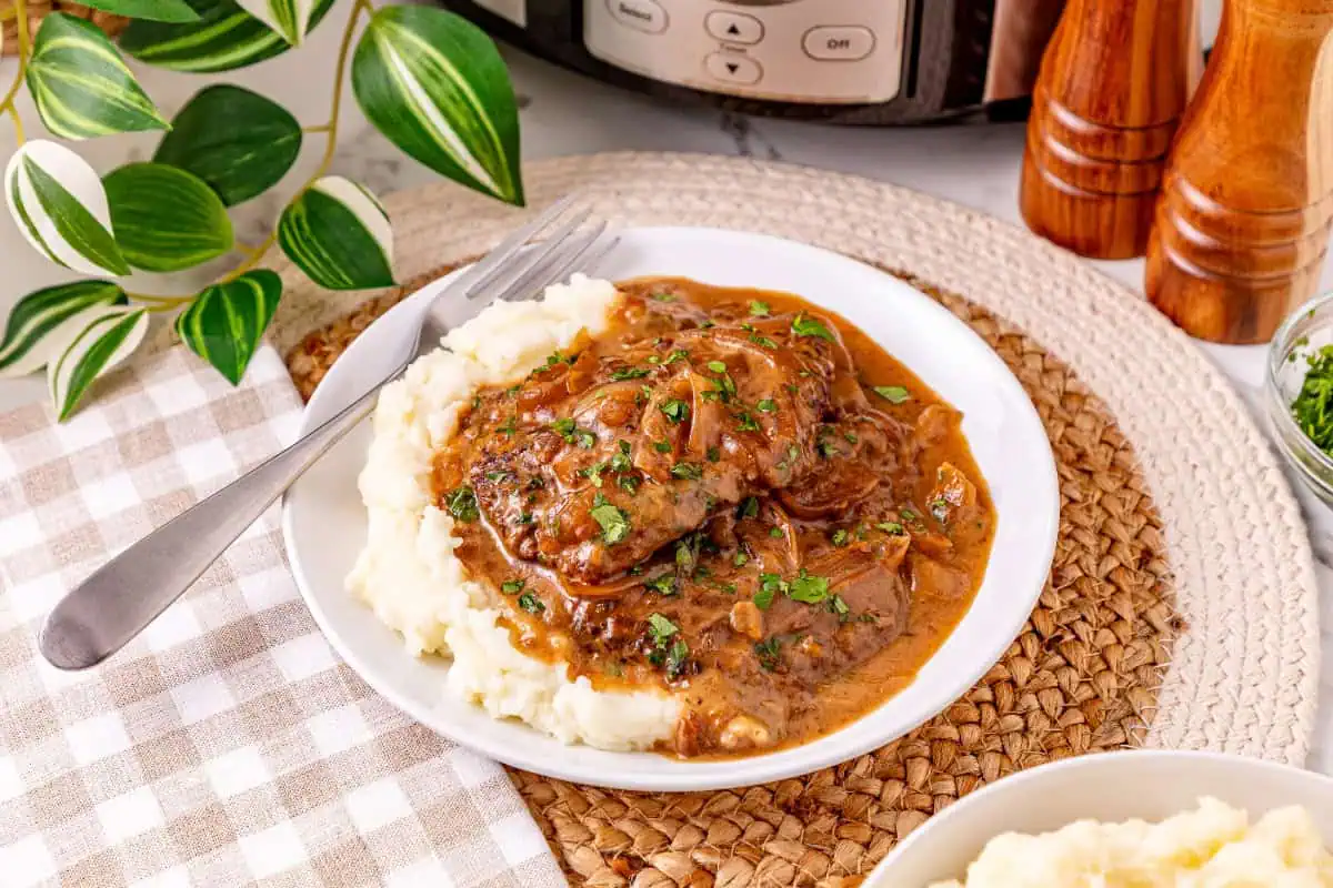 Plate of slow cooker cube steak and gravy with mashed potatoes