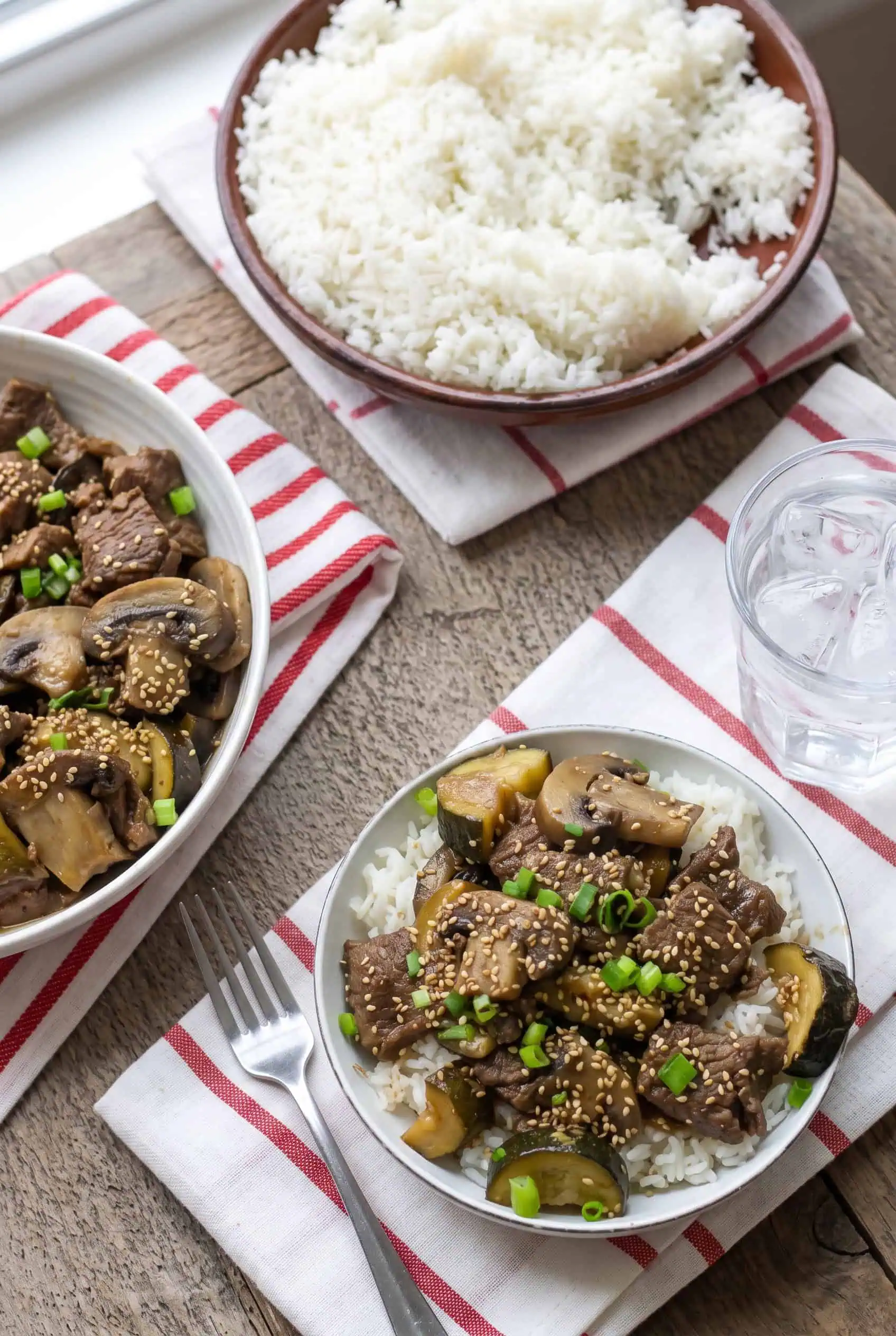 Hibachi steak bites served over white rice beside a separate bowl of rice.